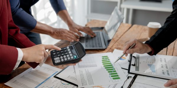 Group of businessmen working together to calculate income, They are revising the financial numbers, Take out financial documents and check them with a calculator,